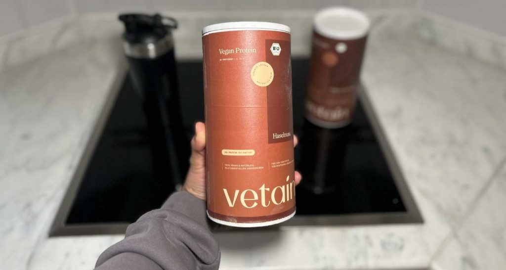 Eine Vetain Vegan Protein Dose ind der Hand