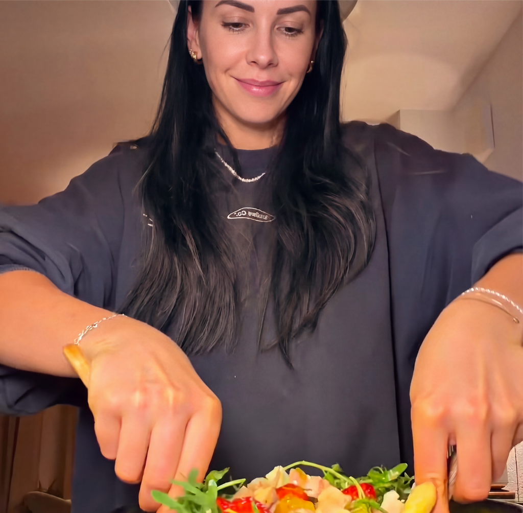 Frau beim Salat anrichten