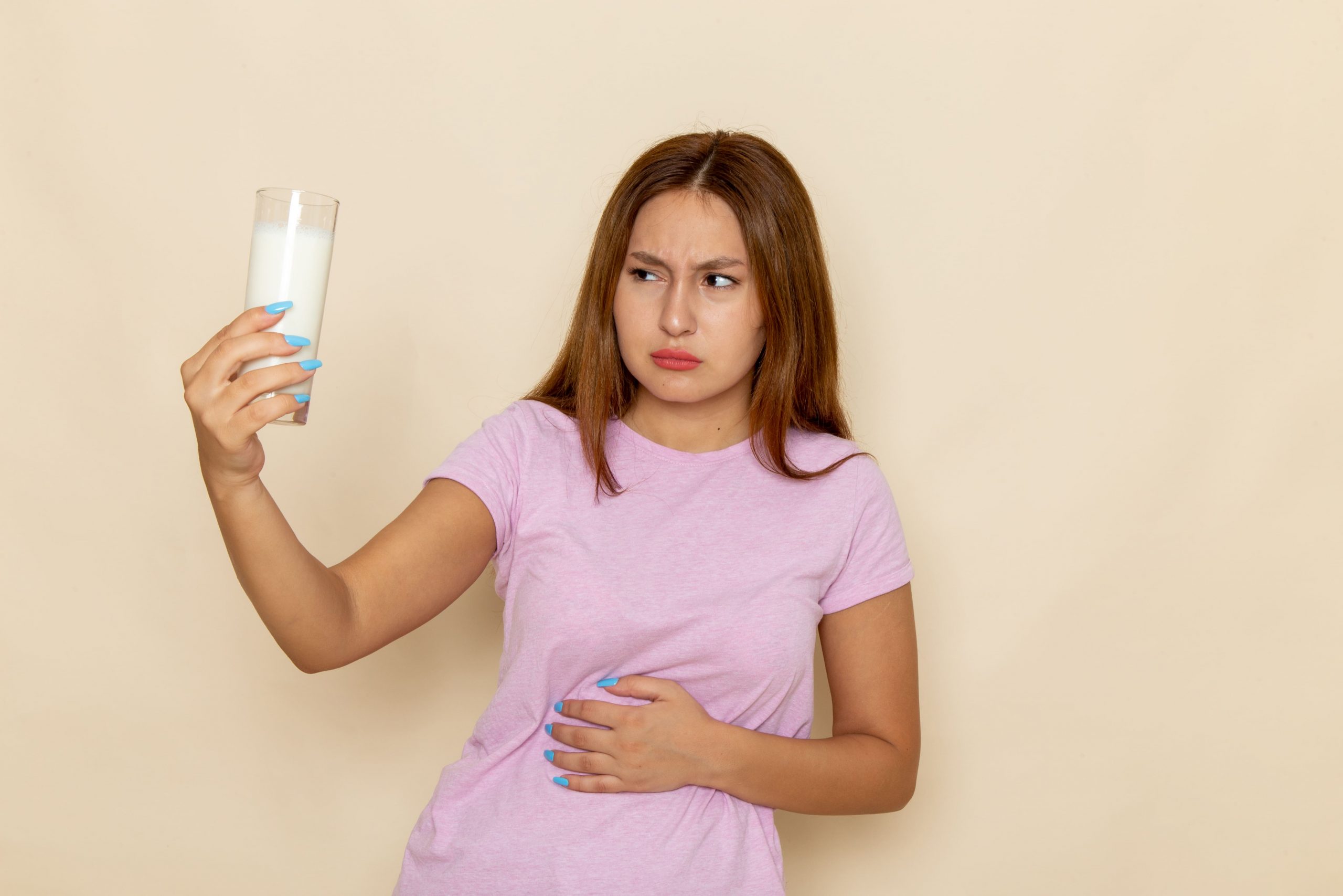 frau mit proteinshake hält sich vor schmerzen den bauch