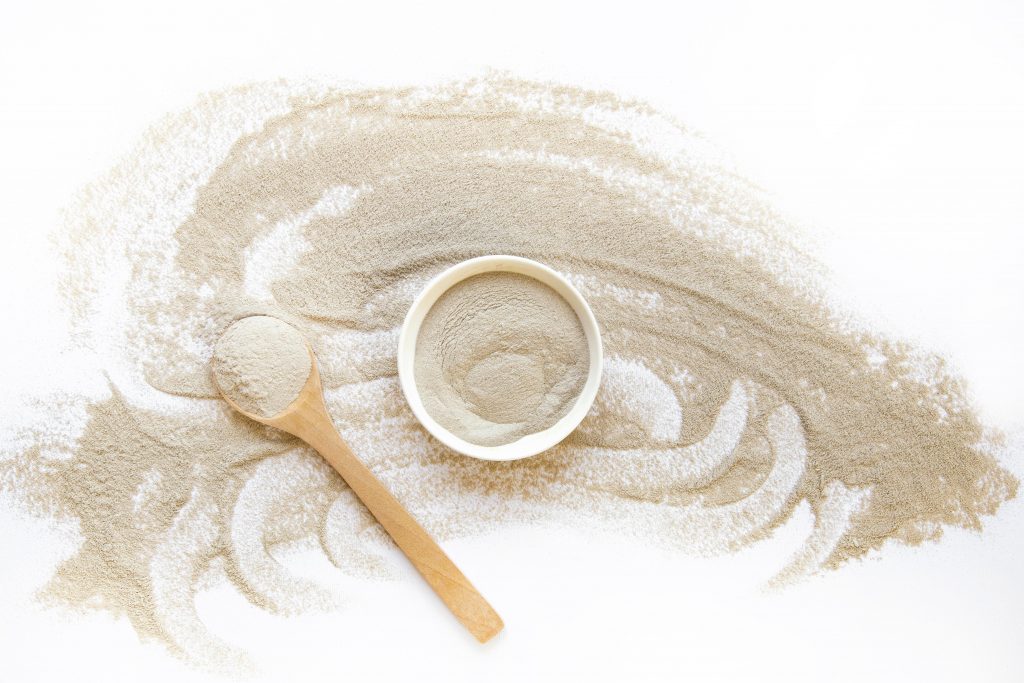Kollagenpulver in einer Schale mit Holzlöffel
